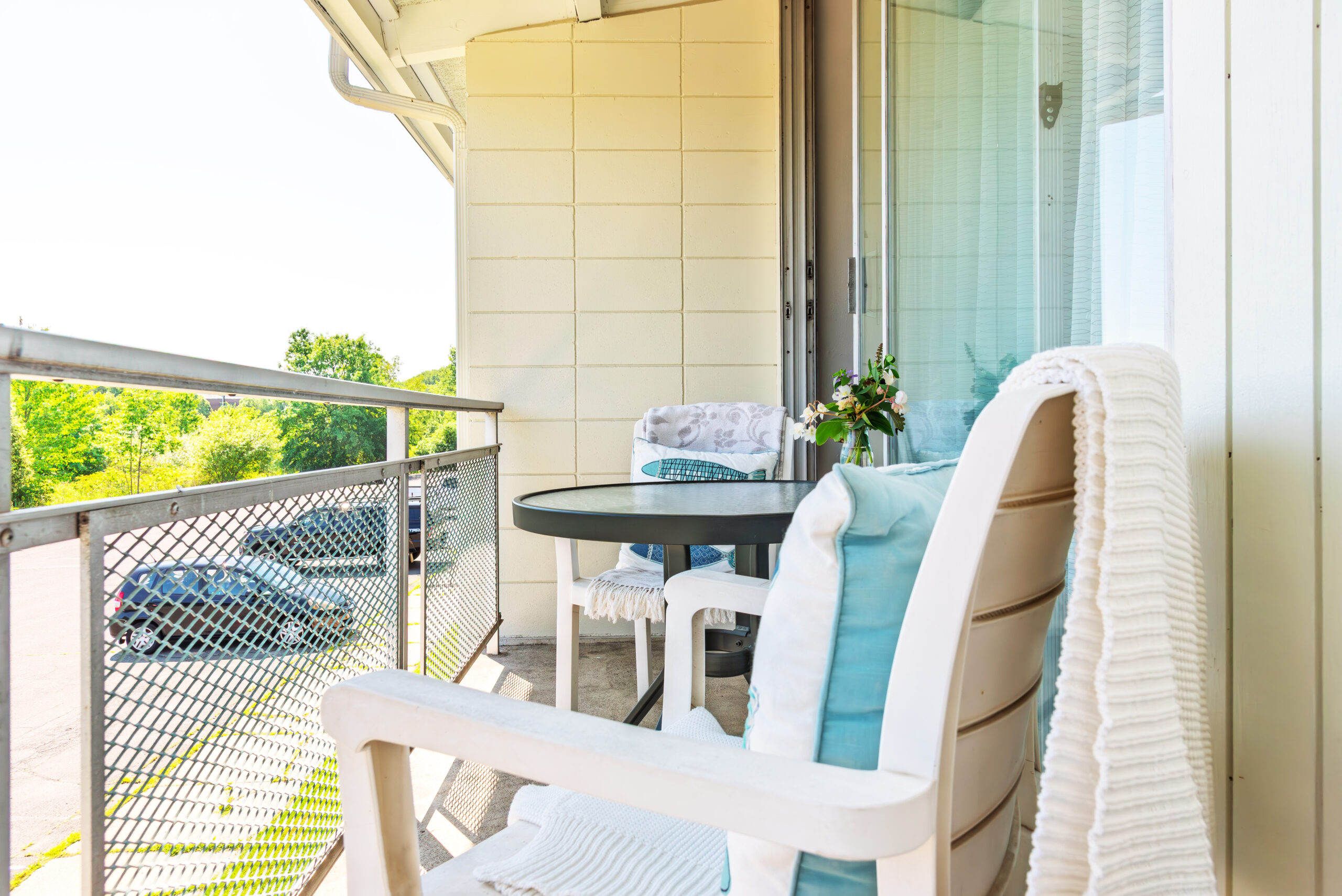 Balcony with wicker chair and garden view at The Residences, Hadley, MA