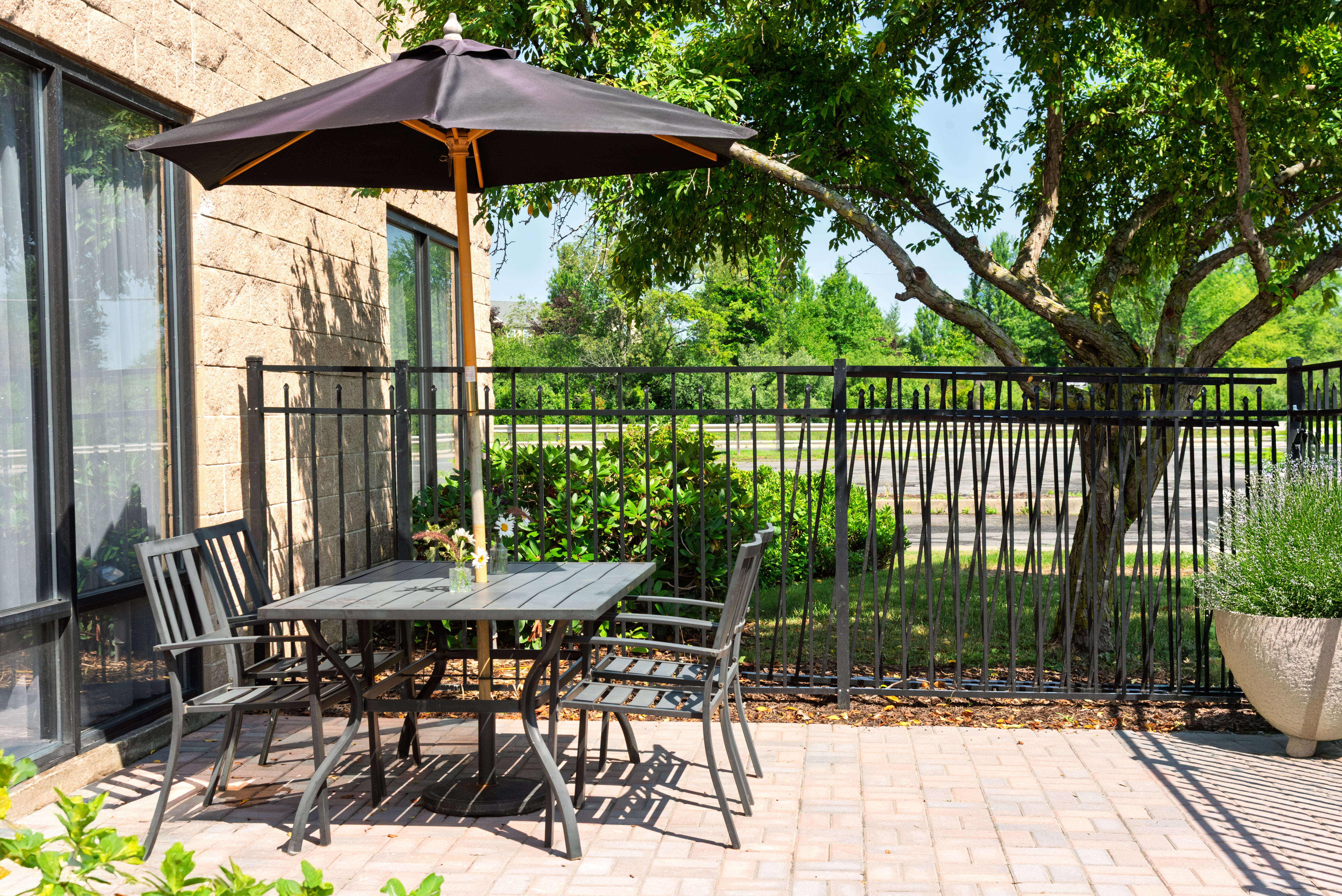 Outdoor patio with umbrella seating at The Residences, 401 Russell Street, Hadley, MA