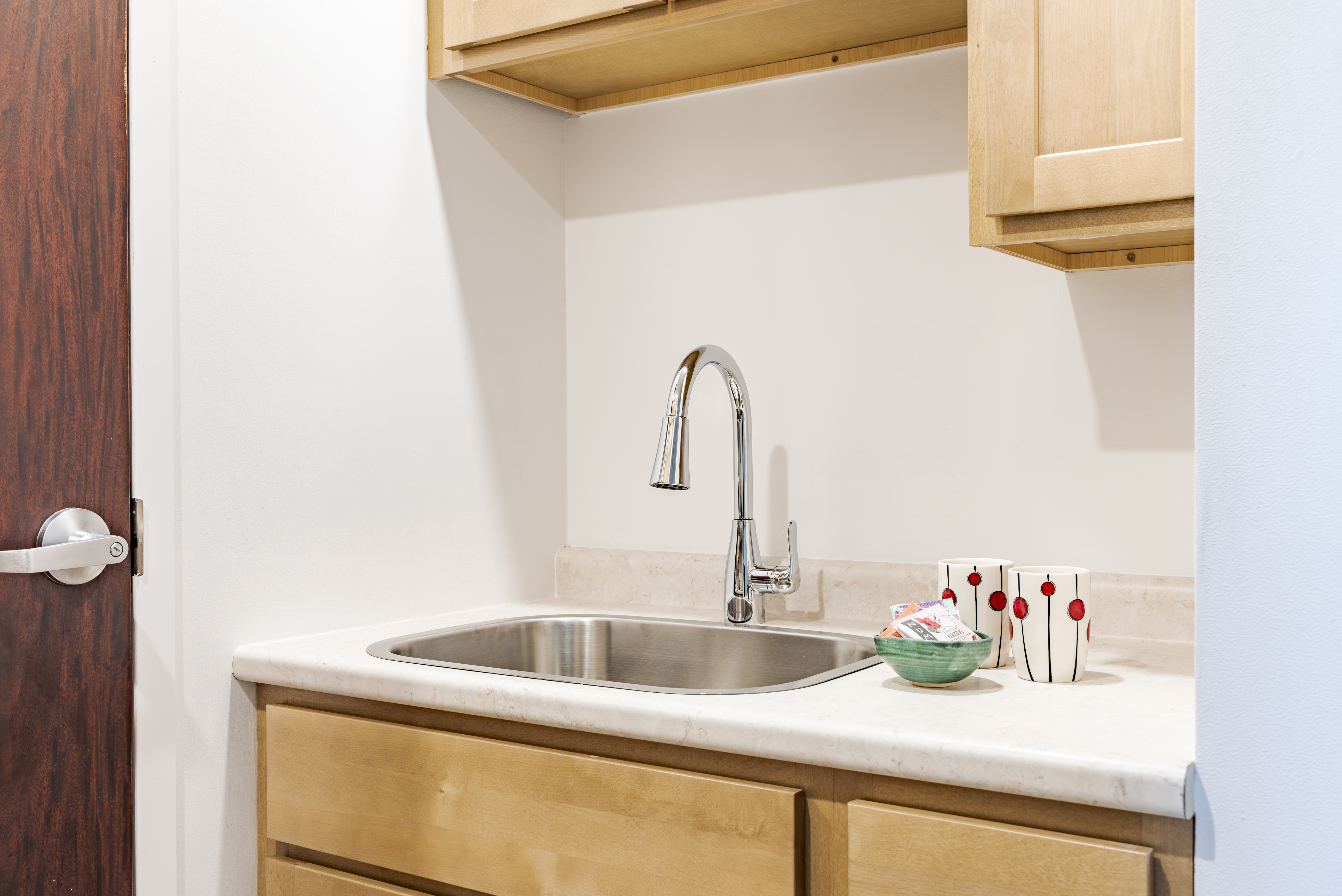 Kitchen sink with marble countertop and mugs at The Residences, Hadley, MA