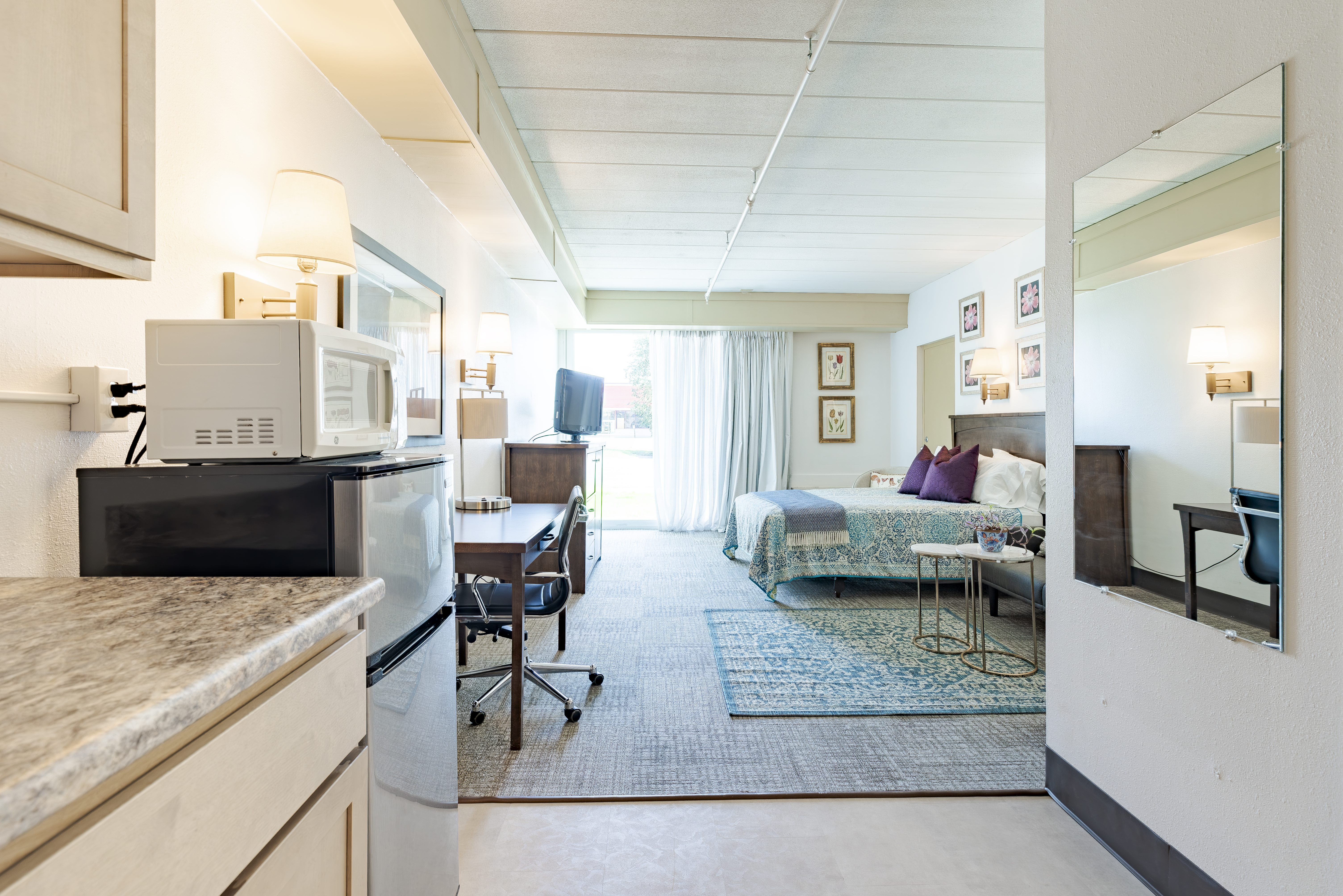 Full view of furnished suite showing kitchenette and bedroom area at The Residences, Hadley, MA